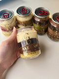 Hand holding a 'Tiramisu Cake Can' with other similar cans on a light background made by GoldBites